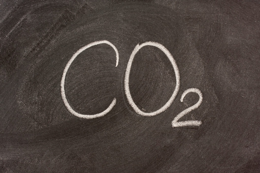 CO2 skrevet med hvitt kritt på sort tavle. Foto.