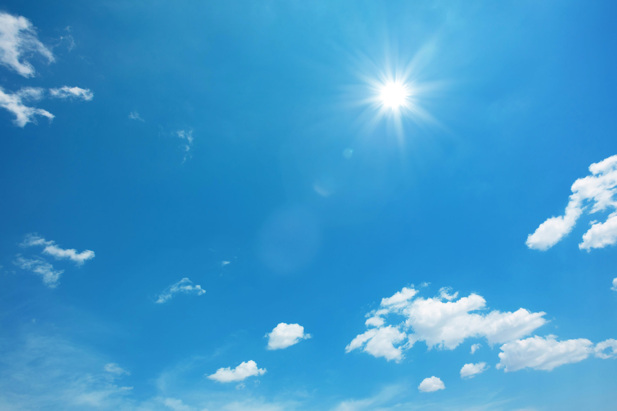 Sol og blåhimmel med noen skyer. Foto